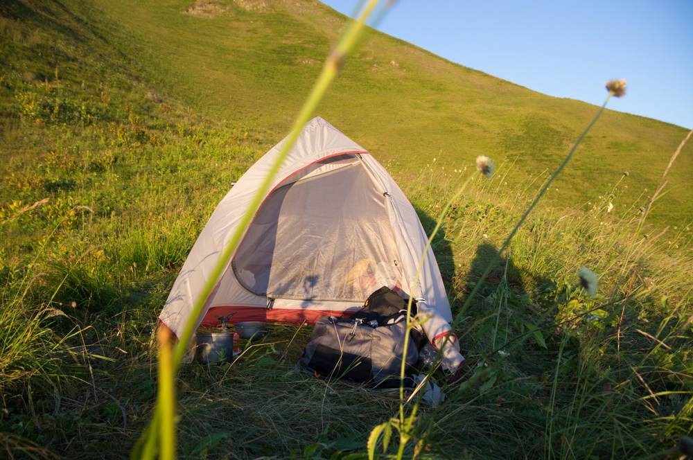 A camping tent pitched on a mountain ridge